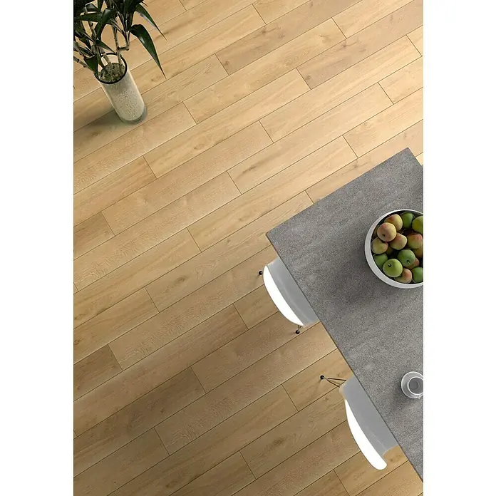 Krono Original Vinylbodenmuster Rocko Wide Sculpta - 297 x 234 x 5 mm, Landhausdiele, Sculpta - Top-Ansicht eines modern gedeckten Esstisches mit Obstschale und Holzboden, der eine warme Atmosphäre ausstrahlt.