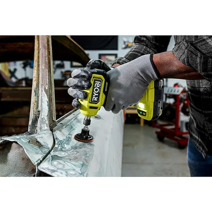 Ryobi ONE+HP Akku-Geradschleifer RDG18C-0 - Ohne Akku, Leerlaufdrehzahl: 0 U/min - 22.500 U/min - Nahaufnahme eines gelben Ryobi ONE+ HP Akku-Bohrschraubers mit Schleifaufsatz beim Bearbeiten einer Metalloberfläche.