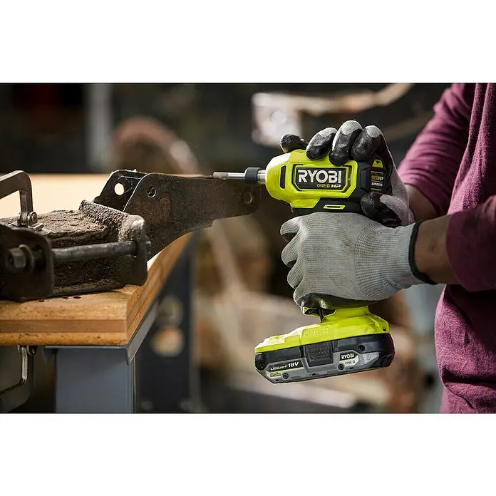 Ryobi ONE+HP Akku-Geradschleifer RDG18C-0 - Ohne Akku, Leerlaufdrehzahl: 0 U/min - 22.500 U/min - Ein gelber und schwarzer Ryobi ONE+ HP Akku-Schlagschrauber wird benutzt, um ein Metallstück in einem Schraubstock zu bearbeiten.