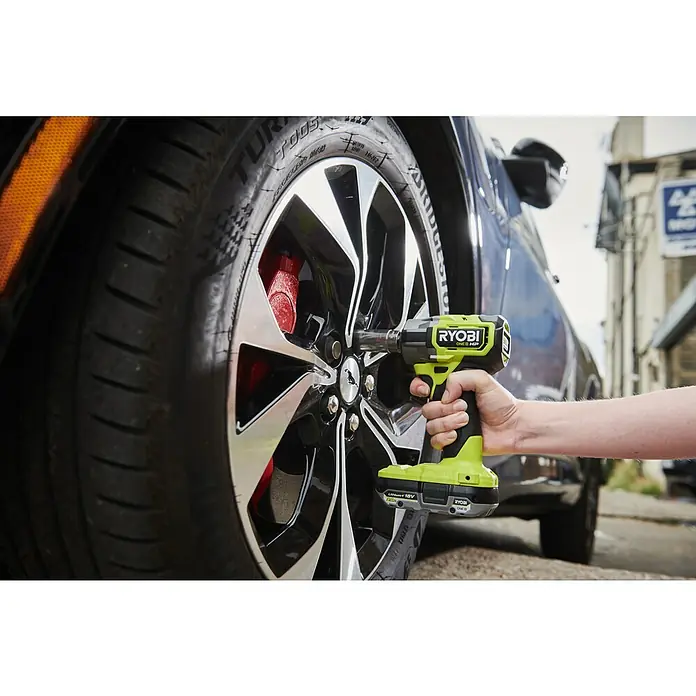 Ryobi ONE+HP Akku-Schlagschrauber RIW1838C-0 - 18 V, Ohne Akku, 450 Nm - Nahaufnahme eines Ryobi ONE+ HP Akku-Schlagschraubers beim Radwechsel, der Leistung und Effizienz vereint.