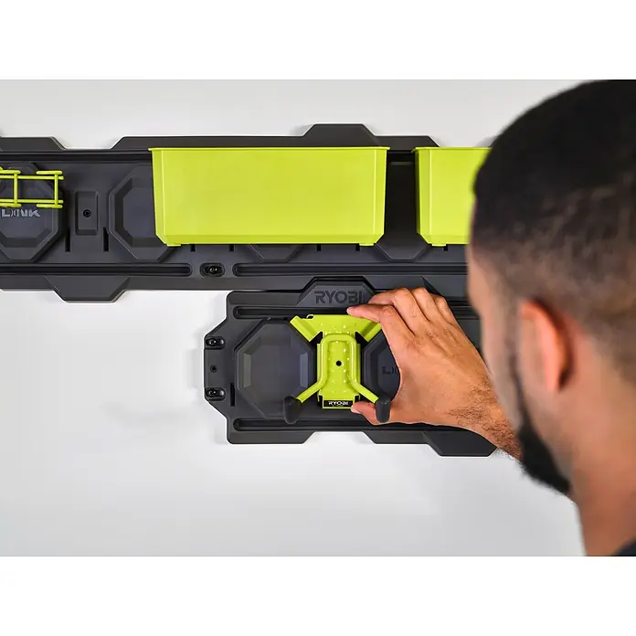 Ryobi Link Systemhalter RSLWPK-7PC - Geeignet für: Elektrowerkzeuge, 7 -tlg. - Nahaufnahme des RYOBI LINK-Systems mit einem Mann, der ein Werkzeug an einem Werkzeugbrett befestigt. Intelligente Werkzeugaufbewahrung.