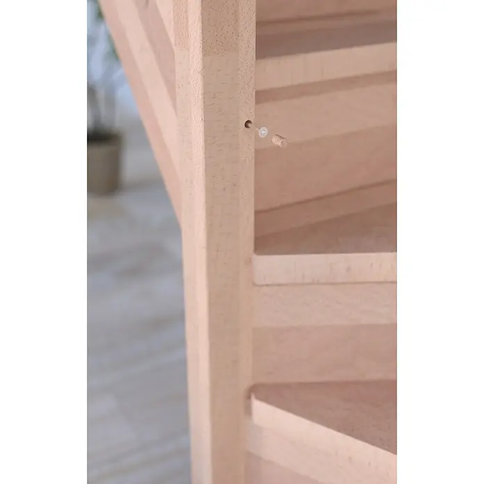 Starwood Raumspartreppe RhodosBreite: 80 cm, Buche, Geschosshöhe: 300 cm, 1/4-gewendelt rechts, Montageseite Geländer: Rechts, Geländer Holz/Edelstahl, Mit Setzstufen - Detailaufnahme einer hellen Holztreppe mit einem unbefestigten Dübel, der die Konstruktion der Treppe zeigt.