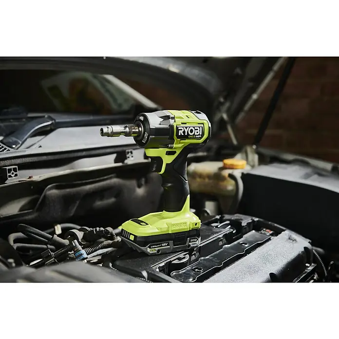Ryobi ONE+HP Akku-Schlagschrauber RIW1838C-0 - 18 V, Ohne Akku, 450 Nm - Akkuschlagschrauber der Marke Ryobi, Modell ONE+ HP, im Motorraum eines Autos. Das Gerät ist gelb-schwarz und hat einen 18V Lithium-Ionen Akku.