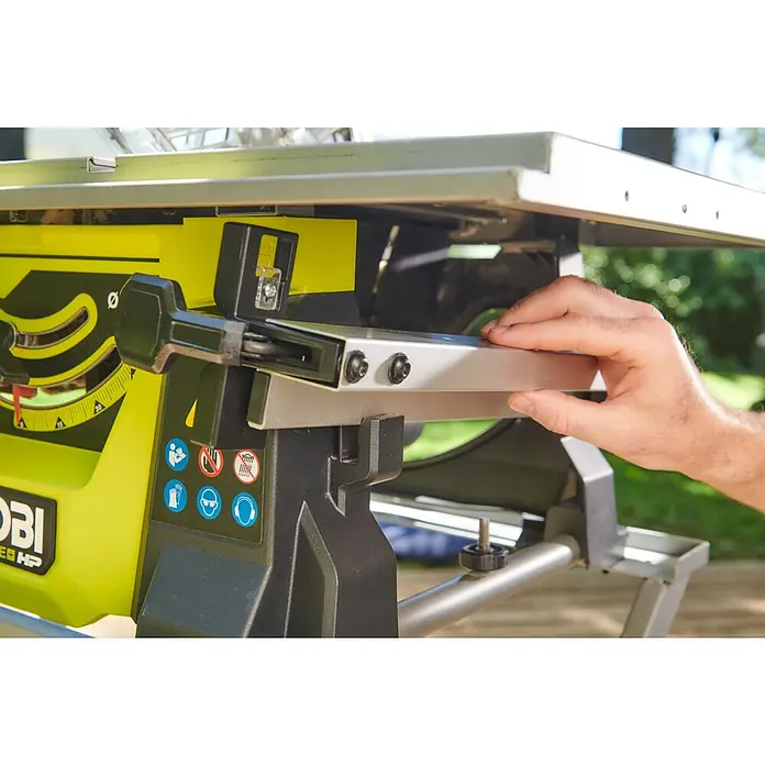 Ryobi ONE+HP Akku-Tischkreissäge RTBS18X-0 - 18 V, Ohne Akku, Durchmesser Sägeblatt: 210 mm - Ein Mann justiert einen Ryobi Tischkreissäge-Anschlag. Die Kreissäge ist gelb und schwarz und auf einem grauen Ständer montiert.