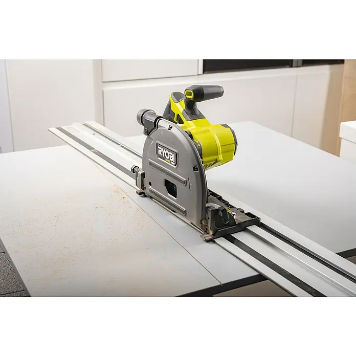 Ryobi ONE+HP Akku-Tauchsäge RPLS18X-0 - 18 V, Ohne Akku, Durchmesser Sägeblatt: 165 mm, Leerlaufdrehzahl: 4.300 U/min - Eine Ryobi Tauchsäge auf einer Führungsschiene, bereit für präzise Schnitte in einem Werkstattumfeld.