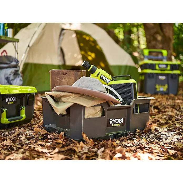 Ryobi Link Werkzeugträger RSL104 - Kunststoff - Camping-Szene mit RYOBI LINK Aufbewahrungsbox, Lampe, Lautsprecher und Zubehör vor einem Zelt. Perfekt für Outdoor-Abenteuer.