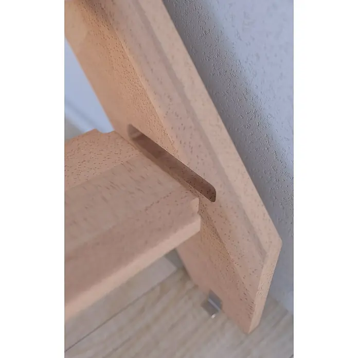 Starwood Raumspartreppe Buche 3000 - Breite: 60 cm, Buche, Material Handlauf: Edelstahl, Weiß, Montageseite Geländer: Rechts, Geschosshöhe: 279,5 cm - Detailaufnahme eines hellen Holzregals, das an einer strukturierten Wand steht und eine Aussparung zur Befestigung zeigt.
