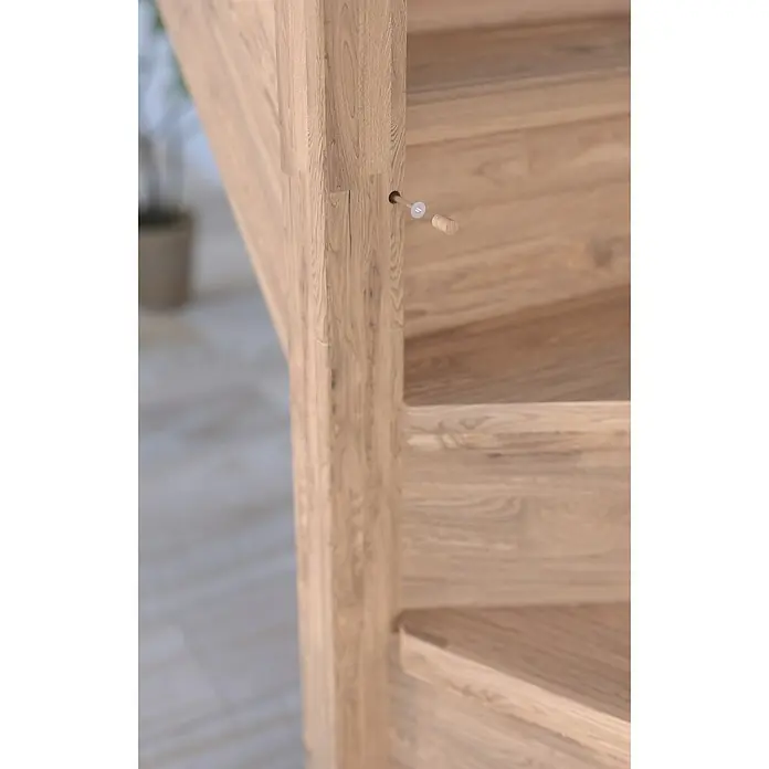 Starwood Raumspartreppe RhodosBreite: 80 cm, Eiche, Geschosshöhe: 300 cm, 1/4-gewendelt links, Montageseite Geländer: Links, Geländer Holz/Edelstahl weiß, Ohne Setzstufen - Nahaufnahme einer Holztreppe mit sichtbaren Holzdetails und einem angedeuteten, noch nicht eingesetzten Holzpflock.