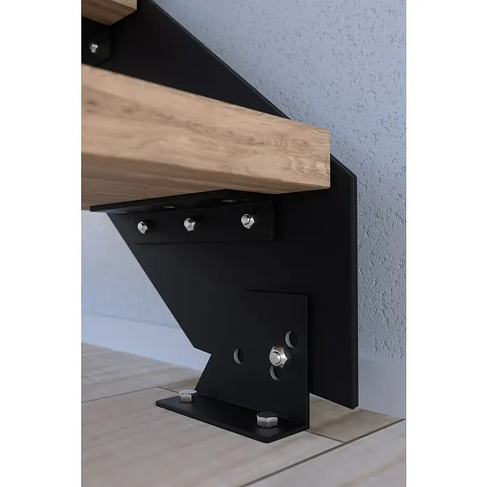 Starwood Wangentreppe Kos - Farbton Metall: RAL 9005, Breite: 108 cm, Buche, Geschosshöhe: 240 cm - 300 cm, Gerade, Designgeländer unbehandelt, Stufen unbehandelt - Detailaufnahme einer modernen Treppenkonstruktion mit schwarzen Metallträgern und Holzstufen, befestigt mit silbernen Bolzen.