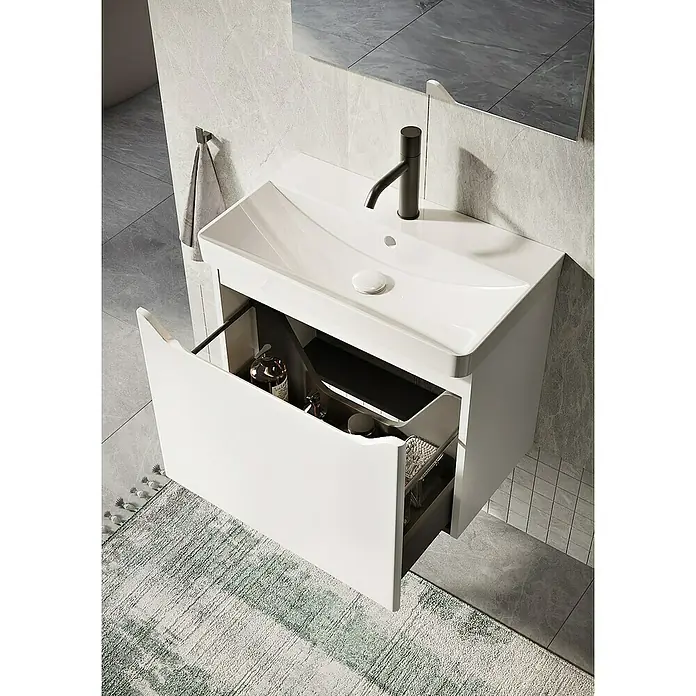 Riva Badmöbel-Set Sierra 2.0 - Gesamtbreite Badmöbel: 60 cm, Weiß, Matt - Ein moderner, weißer Waschtischunterschrank mit einer offenen Schublade, die diverse Badezimmerutensilien zeigt, und einem schwarzen Wasserhahn.