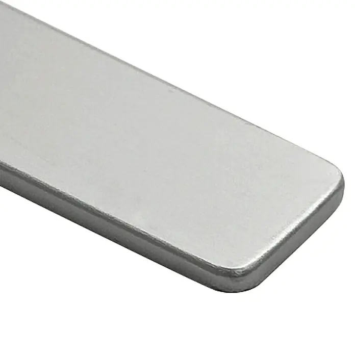 Top Form Perfil final para encimeras - Plata, An x L: 3 x 63 cm - Primer plano de una pieza metálica rectangular brillante con bordes redondeados sobre un fondo negro.