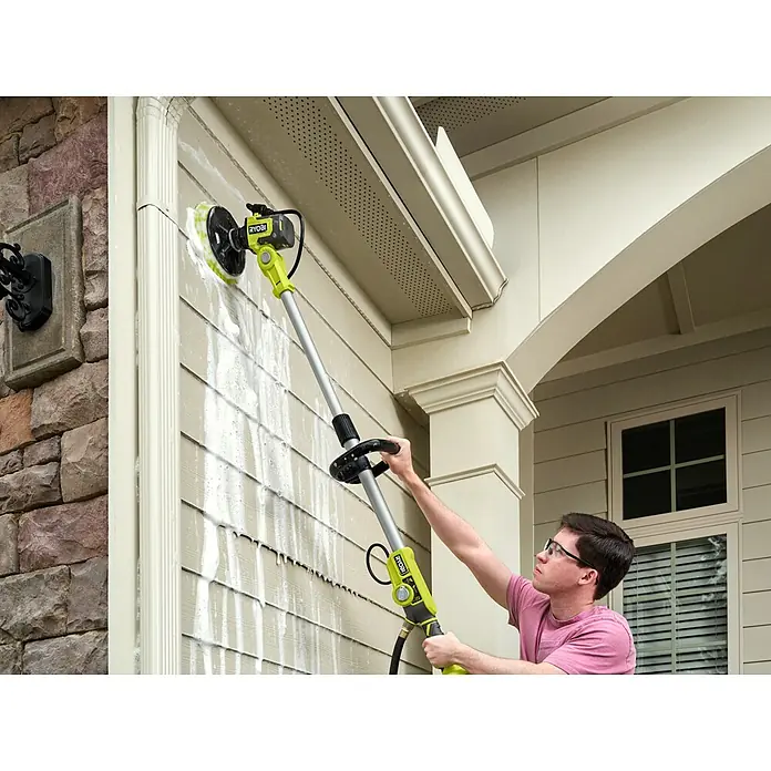 Ryobi ONE+ Akku-Reinigungsbürste RWTS18-0 - 18 V, Ohne Akku - Mann benutzt einen Ryobi Power Scrubber mit Teleskopstiel, um die Hausfassade zu reinigen. Ideal für die mühelose Aussenreinigung.