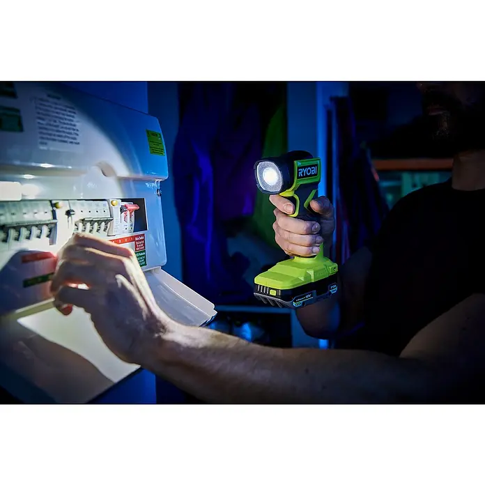 Ryobi ONE+ Akku-Taschenlampe RLF18-0 - 18 V, Ohne Akku, Lichtstrom: 280 lm - Ein Mann, der eine Ryobi-Lampe hält, während er an einem elektrischen Bedienfeld arbeitet.