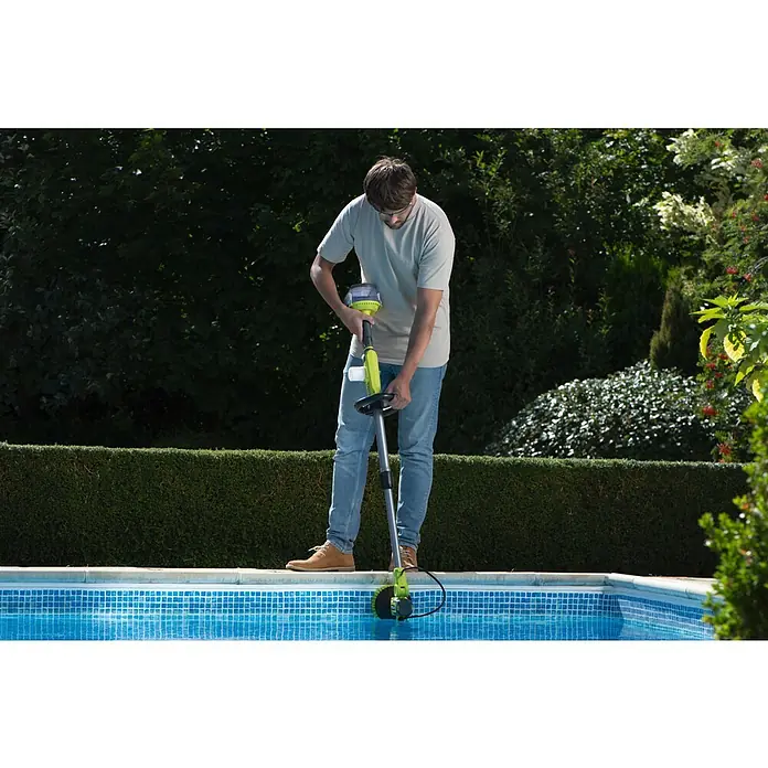 Ryobi ONE+ Akku-Reinigungsbürste RWTS18-0 - 18 V, Ohne Akku - Ein Mann, der einen Poolreiniger am Beckenrand bedient, mit Büschen und Bäumen im Hintergrund.