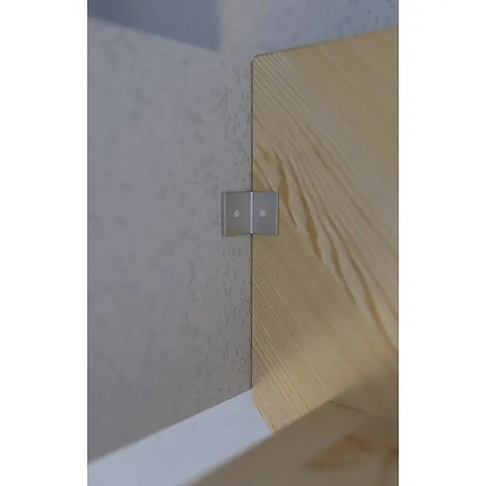 Starwood Raumspartreppe Korfu - Breite: 80 cm, Fichte, Geschosshöhe: 300 cm, Gerade, Montageseite Geländer: Rechts, Geländer Holz/Edelstahl, Mit Setzstufen - Nahaufnahme einer Winkelverbindung zwischen einer grauen Wand und einem hellen Holzstück, fixiert mit einem glänzenden Metallwinkel.