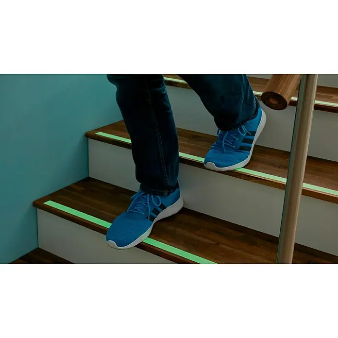 Tesa Cinta de señalización antideslizante Fluor - L x An: 5 m x 25 mm - Persona bajando escaleras con iluminación LED, que proporciona seguridad y ambiente.