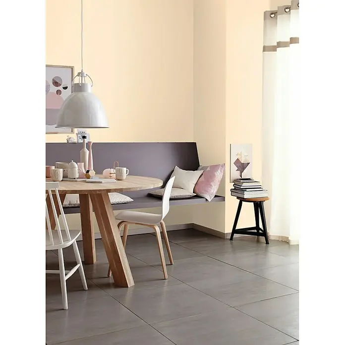 SCHÖNER WOHNEN-Farbe MyColour Wandfarbe - My Sandstone, Matt, 5 l - Ein Esszimmer mit einem runden Tisch, Stühlen und einer Bank mit Kissen, das eine gemütliche und einladende Atmosphäre schafft.