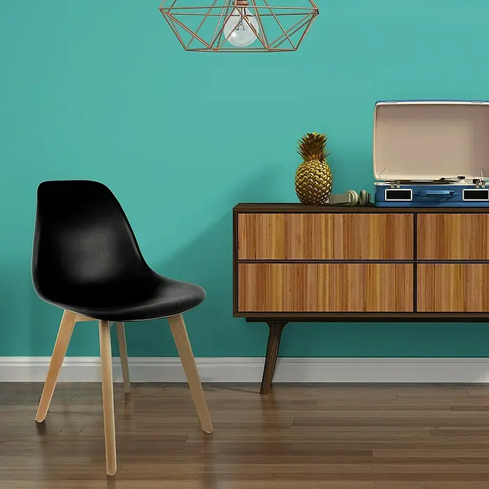 Home Deco Factory Silla Stockholm - Negro, 4 pzs. - Elegante silla negra con patas de madera frente a una pared turquesa con un gabinete, tocadiscos y piña encima.