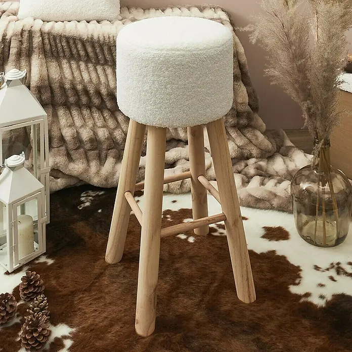 Home Deco Factory Taburete rizado Freya - Blanco - Taburete redondo con funda de piel blanca y patas de madera clara sobre una alfombra marrón y blanca.
