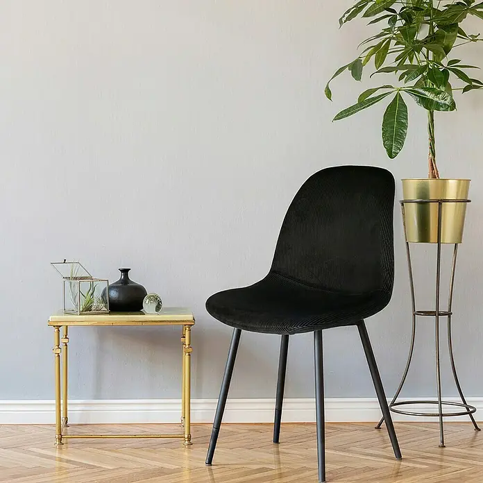 Home Deco Factory Silla Giulia - Negro, 4 pzs. - Interior elegante con una silla de terciopelo negro, una mesa auxiliar dorada y una planta de interior en una maceta dorada.