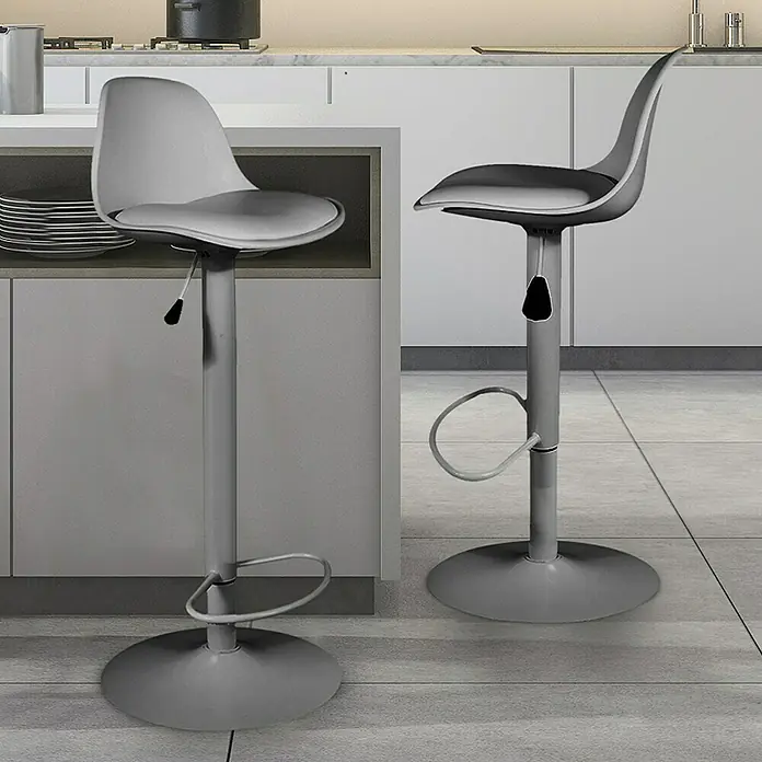Home Deco Factory Taburete de cocina Isak - Altura: 104 mm, Gris - Dos taburetes de bar grises con reposapiés en una cocina moderna. Los taburetes tienen una base redonda y un asiento curvo.