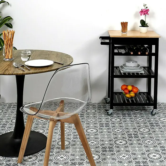 Home Deco Factory Carro de cocina Bristot Indus - L x An x Al: 40 x 62,5 x 85,5 cm, Negro/Pino - Fotografía de producto de una silla transparente, una mesa de madera con vajilla y un carrito de servicio negro lleno de comida y bebida.