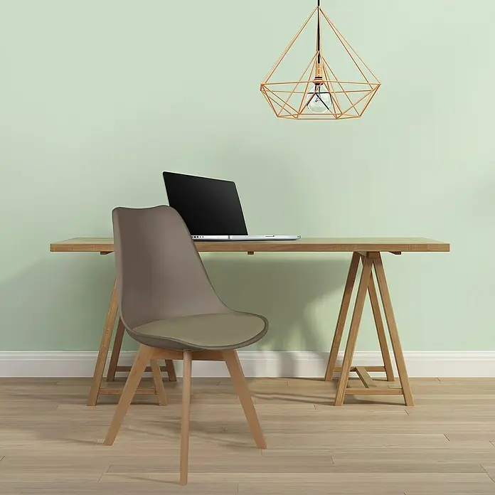 Home Deco Factory Silla Copenhague - Marrón, 4 pzs. - Primer plano de una silla moderna de plástico marrón y madera, situada frente a un escritorio con un portátil y una lámpara geométrica.