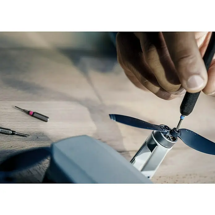 Bosch Expert Universalbohrer HEX-9 Hard Ceramic + HEX-9 Multi Construction - Durchmesser Bohrer: 6 mm - Ein Mann repariert eine Drohne mit einem Schraubenzieher, um die Rotorblätter zu befestigen. Werkzeug von Bosch liegt daneben.