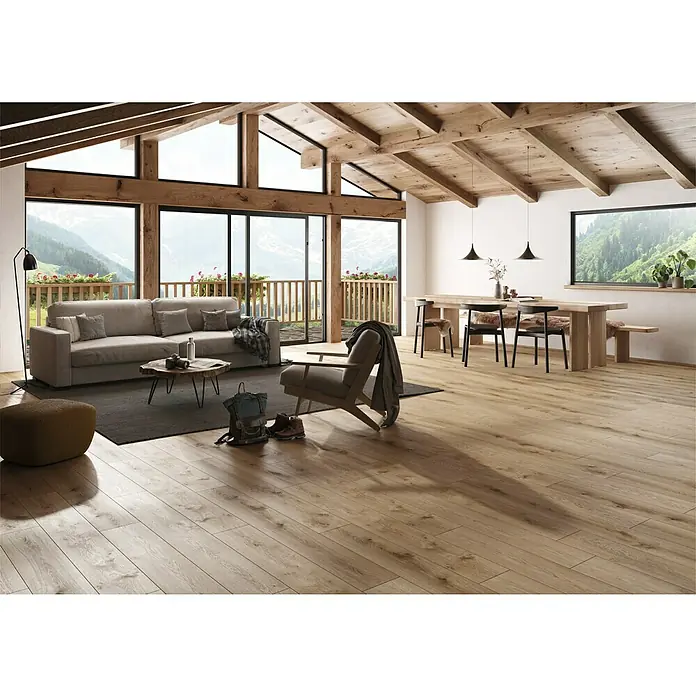 Suelo vinílico Corepel Natural - 195 x 1.380 x 5,5 mm, Beige - Salón luminoso con vigas de madera, suelo de parqué, sofá y mesa de comedor. Grandes ventanales con vistas a la montaña. Ambiente acogedor.