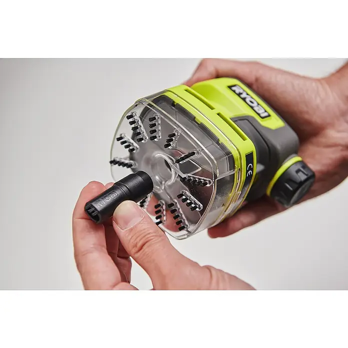 Ryobi 4V USB Akku-Staubsauger Mini RDV4-0 - 4 V, Ohne Akku, 70 ml - Ein Detailaufnahme eines Ryobi-Geräts mit austauschbarem Bürstenaufsatz, das in einer Hand gehalten wird.