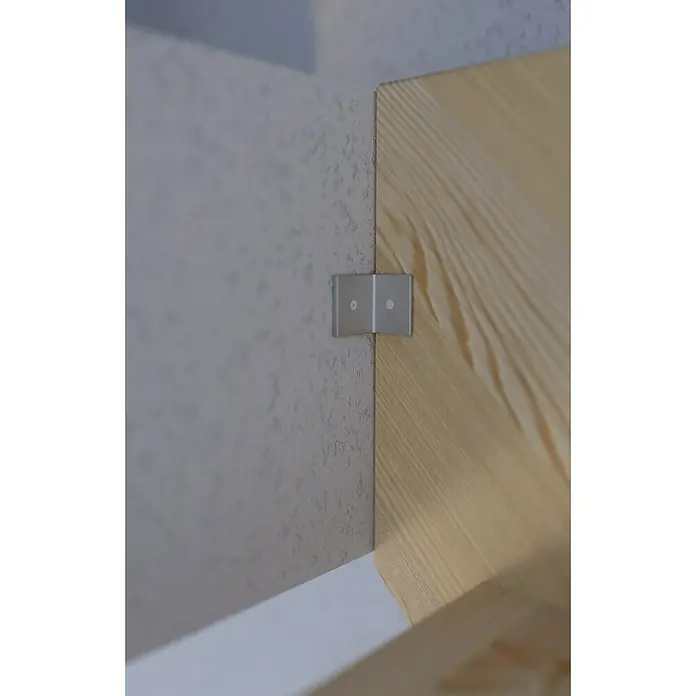 Starwood Raumspartreppe Fichte 2000Breite: 60 cm, Fichte, Holzgeländer zwei Querleisten, Geschosshöhe: 279,5 cm - Nahaufnahme einer silbernen Winkelverbindung, die ein helles Holzbrett an einer grauen, strukturierten Wand befestigt und Stabilität verleiht.