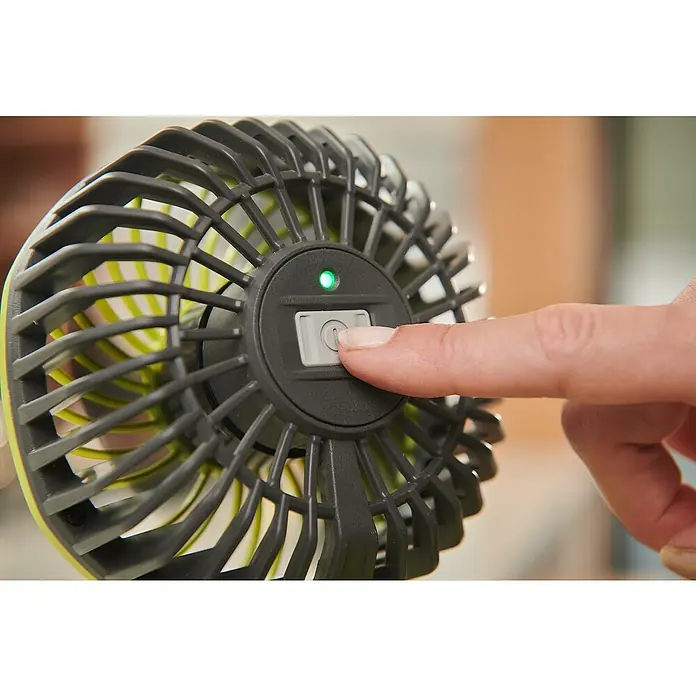 Ryobi 4V USB Akku-Ventilator RCF4-0 - 4 V, Ohne Akku - Ein Finger drückt den Netzschalter eines tragbaren Ventilators. Das Gerät hat ein grünes Licht, das anzeigt, dass es eingeschaltet ist.