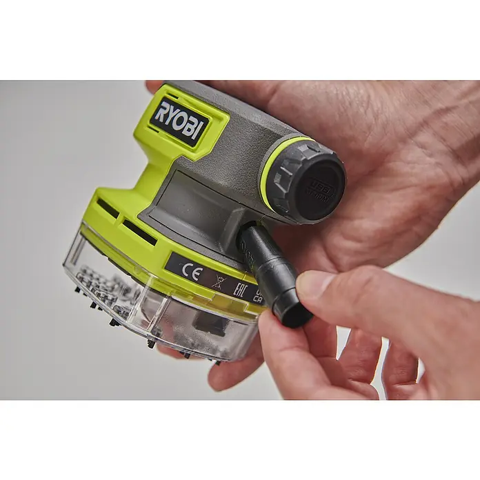 Ryobi 4V USB Akku-Staubsauger Mini RDV4-0 - 4 V, Ohne Akku, 70 ml - Nahaufnahme eines Ryobi Staubsaugers, der von einer Hand gehalten wird und bereit ist, ein Zubehörteil anzuschließen.