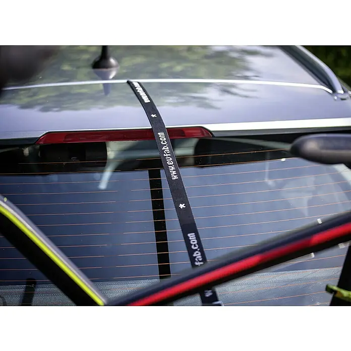 Eufab Fahrradträger Amber IV - Geeignet für: 4 Fahrräder, Passend für: Fahrzeuge mit Anhängerkupplung - Detailaufnahme eines Fahrradträgers am Heck eines Autos, mit Fokus auf den schwarzen Spanngurt mit der Aufschrift "www.eufab.com".