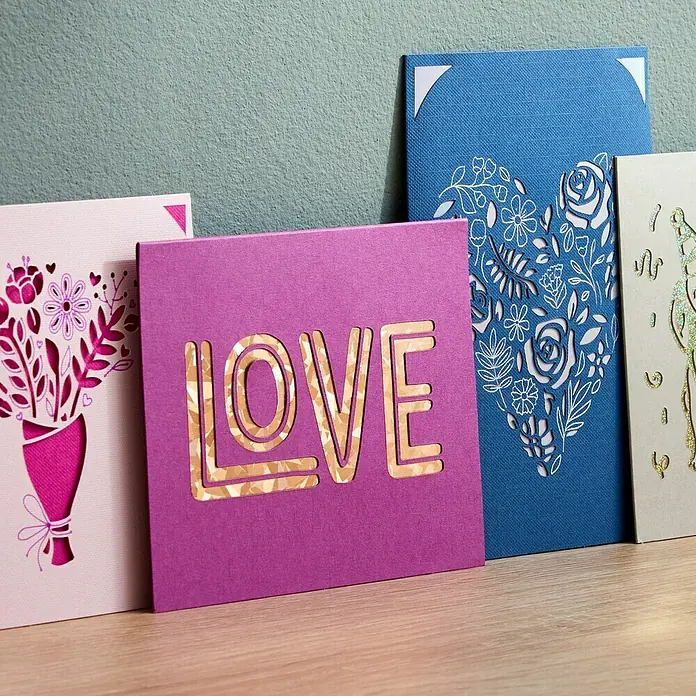 Cricut Joy Xtra Schneidematte Card Mat - L x B: 16,8 x 12 cm, Passend für: Cricut Karten - Nahaufnahme von vier einzigartigen, lasergeschnittenen Karten mit Liebes- und Blumenmotiven in verschiedenen Farben.