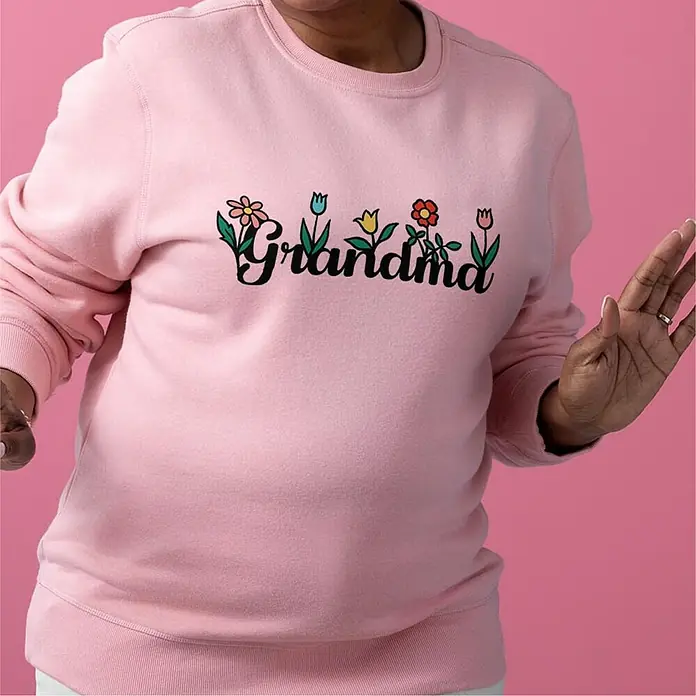 Cricut Joy Xtra Schneideplotter Starter Bundle - Weiß, Bluetooth, Schnittbreite: 21,6 cm, Schnittlänge: 1,2 m - Rosa Pullover mit der Aufschrift "Grandma", verziert mit bunten Blumen. Ideal für eine liebevolle Oma, die Komfort schätzt!