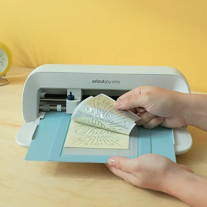 Cricut Joy Xtra Schneidematte Card Mat - L x B: 16,8 x 12 cm, Passend für: Cricut Karten - Nahaufnahme eines Cricut Joy Xtra-Geräts, das ein detailliertes "Danke"-Design auf einem Blatt Vinyl erstellt, ideal für Bastelprojekte.