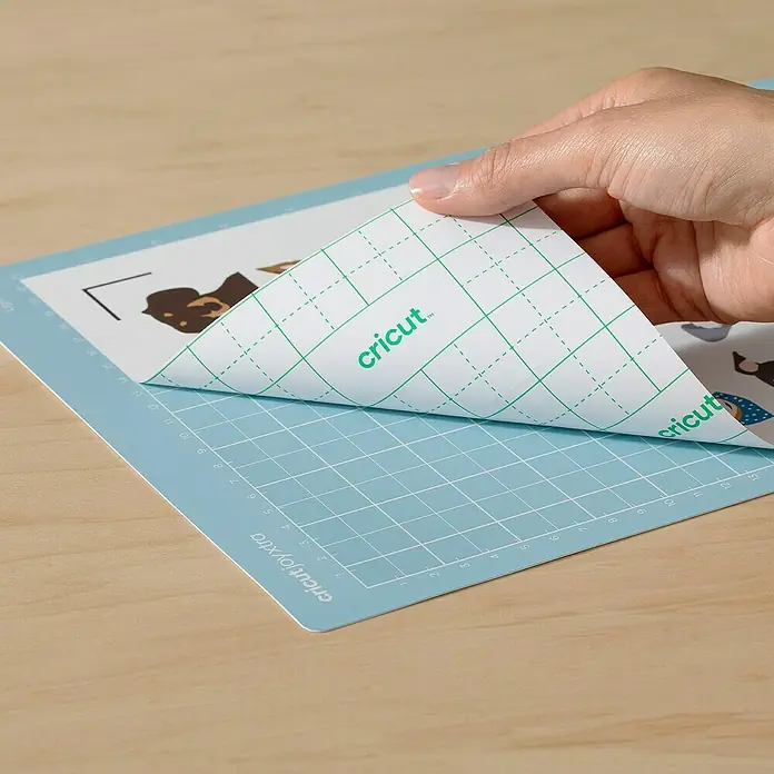 Cricut Joy Xtra Schneidematte LightGrip - Hellblau, L x B: 30,5 x 21,6 cm, Passend für: Cricut Joy Xtra™ - Nahaufnahme einer Cricut Joy Xtra Schneidematte mit abziehbarer Schutzfolie, die das Produkt und seine Benutzerfreundlichkeit hervorhebt.