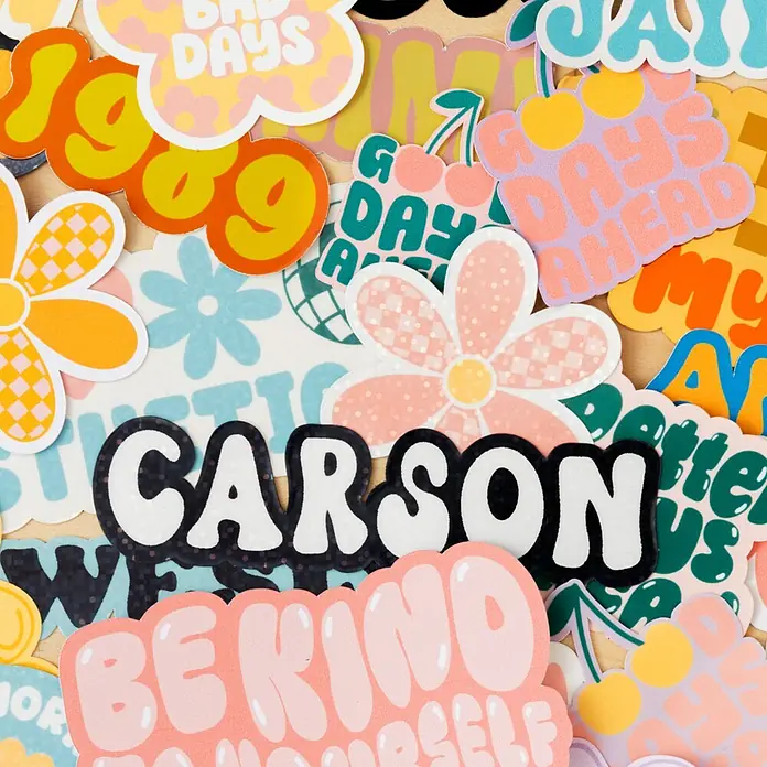 Cricut Joy Xtra Schneideplotter Starter Bundle - Weiß, Bluetooth, Schnittbreite: 21,6 cm, Schnittlänge: 1,2 m - Eine Nahaufnahme von diversen farbenfrohen Aufklebern mit Mustern, Blumen, und Texten wie "Carson" und "Be Kind". Perfekt zum Dekorieren.