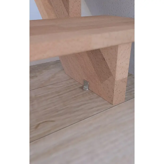 Starwood Raumspartreppe LindosBreite: 80 cm, Buche, Geschosshöhe: 300 cm, Gerade, Montageseite Geländer: Wahlweise links/rechts, Designgeländer Edelstahl, Mit Setzstufen - Nahaufnahme einer hellen Holztreppe mit einer silbernen L-förmigen Halterung zur Befestigung am Boden.