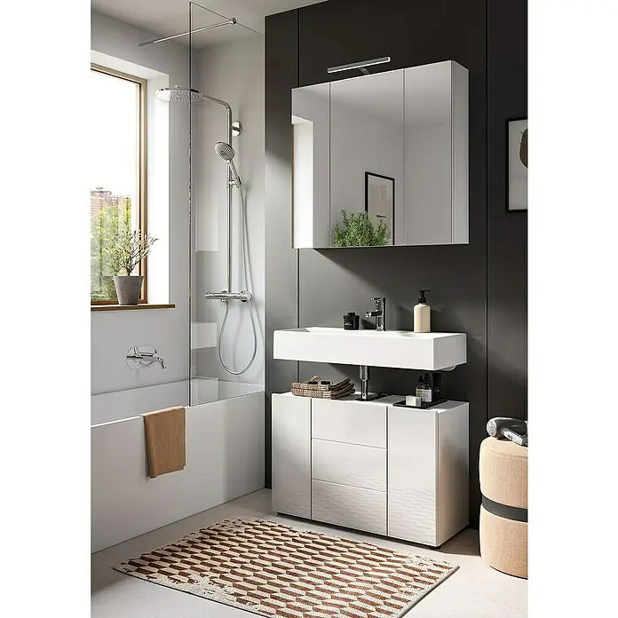 xonox.home Vira Badmöbel-Set Vira - 82 cm, Weiß, Glänzend, Ohne Beleuchtung - Das Bild zeigt ein modernes Badezimmer mit einem Waschtisch, Spiegelschrank und einer Badewanne mit Duschabtrennung. Der Fokus liegt auf dem Waschtisch.