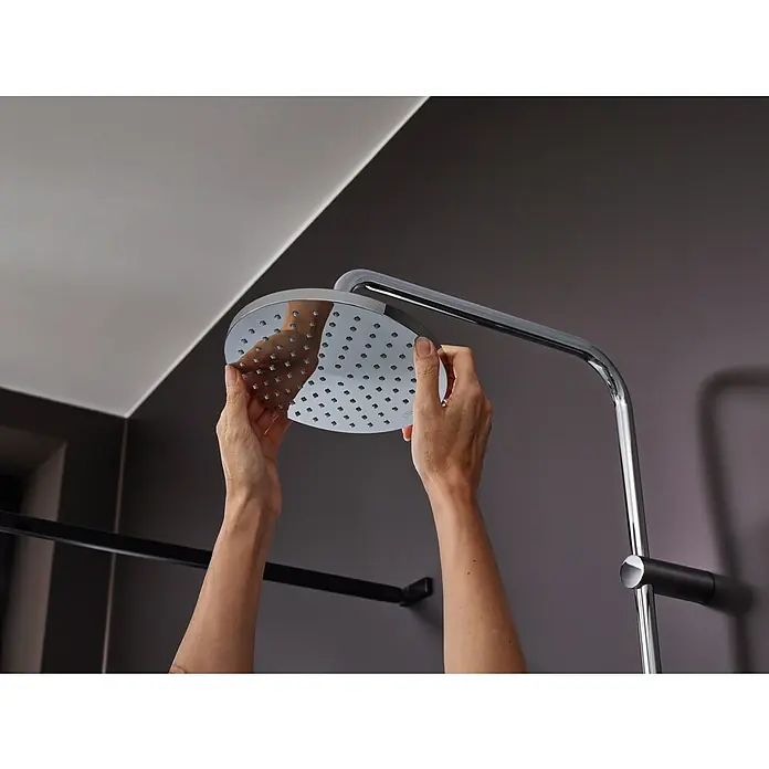 Hansgrohe Vernis Blend Sistema de ducha 200 - Caudal de agua: 6,8 l/min, Cromo - Se está acoplando un cabezal de ducha redondo a un moderno sistema de ducha cromado en un baño elegante.