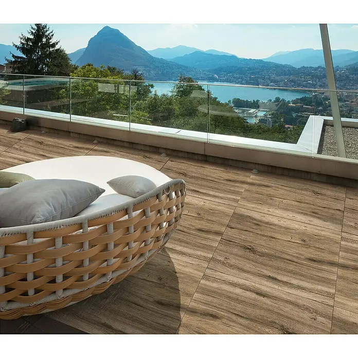 Terrassenfliese Strobus - 40 x 120 x 2 cm, Oak/Braun, Matt - Terrassendielen aus Holzverbundstoff mit einer runden Sitzgruppe und Blick auf einen See und Berge. Die Dielen sind witterungsbeständig und pflegeleicht.