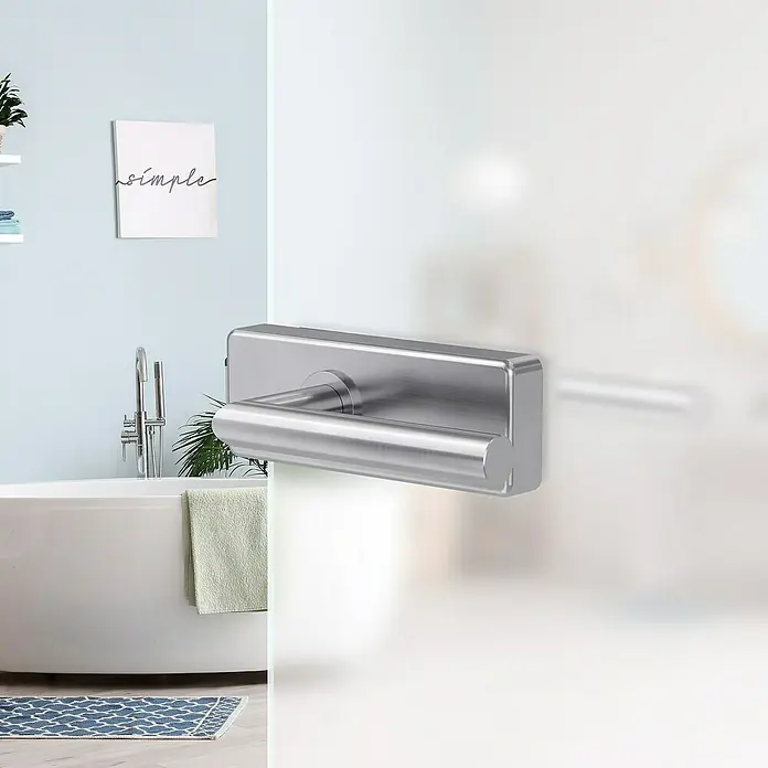 Diamond Doors Glastürbeschlag Style Premium UV - Edelstahloptik, Bandbohrung/Bänder: Office 3-teilig, Unverschließbar - Nahaufnahme eines modernen, silbernen Handtuchhalters mit einem minimalistischen Design, der an einer milchigen Glaswand befestigt ist.