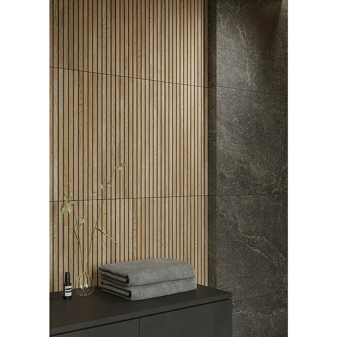 Wandfliese Boseli Wood - 29,8 x 59,8 cm, Beige, Matt - Das Foto zeigt ein modernes Badezimmerdesign mit einer stilvollen Holzpaneelwand, grauen Handtüchern und einer eleganten Waschtischplatte.