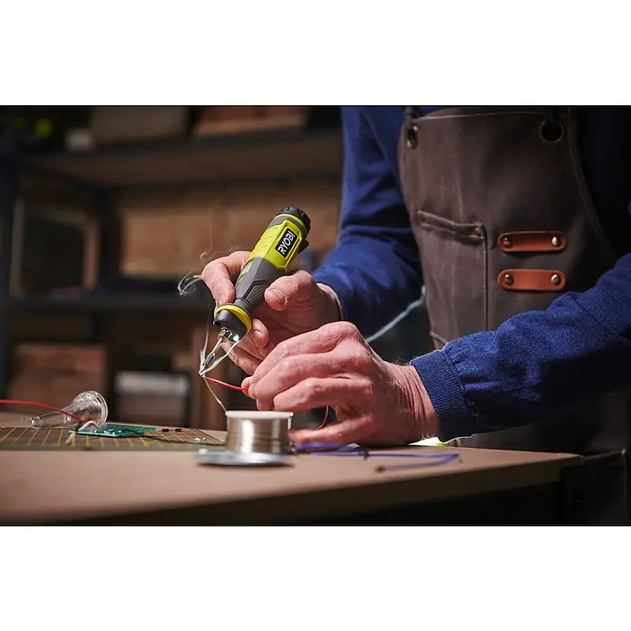 Ryobi 4V USB Akku-Lötstift RSI4-120G - 4 V, 1 Akku, 2 Ah - Ein Ryobi Lötkolben wird zum Löten von Drähten auf einer Werkbank verwendet. Das Werkzeug liegt gut in der Hand und erzeugt präzise Verbindungen.