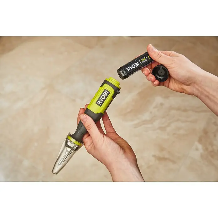 Ryobi 4V USB Akku-Lötstift RSI4-0 - 4 V, Ohne Akku - Ein Ryobi USB Lithium Akku-Bohrschrauber mit aufgesetztem Staubfangaufsatz wird von einer Person gehalten, der Akku wird eingesetzt.