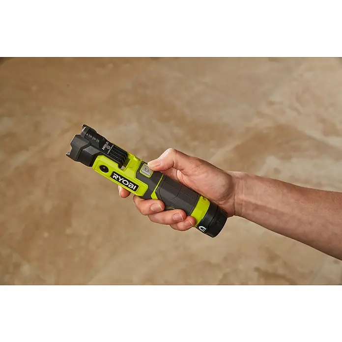 Ryobi 4V USB Akku-Taschenlampe RLP4 - 4 V, 1 Akku, Lichtstrom: 640 lm - Eine Hand hält eine Ryobi-Arbeitsleuchte mit grünem Gehäuse und schwarzem Griff. Der Finger drückt den Einschaltknopf der Lampe.