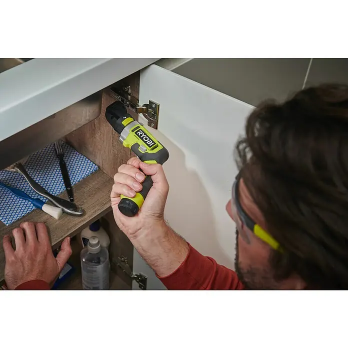 Ryobi 4V USB Akkuschrauber RSD4-120TA2 - 4 V, 1 Akku, 5 Nm - Ein Mann befestigt eine Schranktür mit einem RYOBI-Akkuschrauber, um die Funktionalität und das Design des Geräts hervorzuheben.