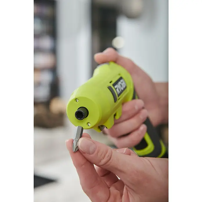 Ryobi 4V USB Akku-Knickschrauber RSDP4-120G - 4 V, 1 Akku, 2 Ah, 5 Nm - Nahaufnahme eines Ryobi-Akkuschraubers mit auswechselbarem Bit, gehalten in einer Hand.